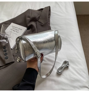 Detail of silver metallic barrel bag with crinkled texture and adjustable straps