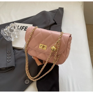 Detailed view of pink quilted handbag with gold chain strap and adjustable metal ball