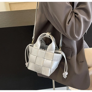 Détail du sac seau tissé argenté avec doublure à cordon et similicuir texturé
