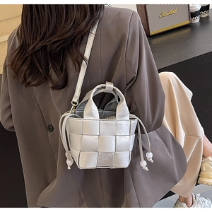 Sac seau tressé argenté avec texture florale embossée et détail de cordon de serrage