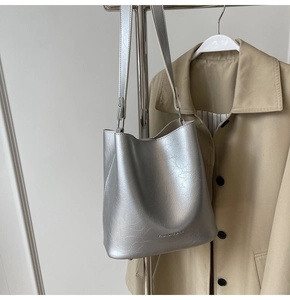 Détail du sac seau argenté à texture métallique avec bandoulière réglable