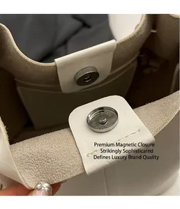 Detailansicht des silbernen Magnetverschlusses an weißer Bucket Bag aus Leder