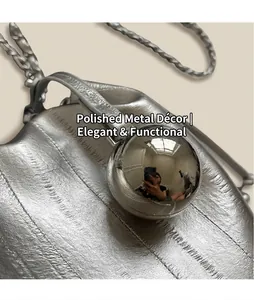 Macro detail of polished spherical metal hardware and textured silver leather chain bag