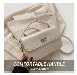 Close-up of beige leather crossbody bag with silver twist lock and minimalist aesthetic