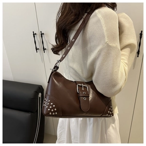 Dettaglio borsa sottobraccio in pelle marrone vintage con rivetti e fibbia in metallo