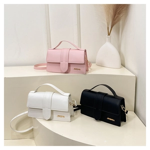 Tre borse a tracolla minimaliste in rosa, bianco e nero su un supporto geometrico