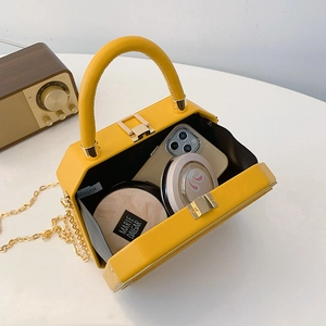 Yellow box-style leather crossbody bag with gold chain strap and interior storage space