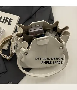 Detailansicht der beigefarbenen Beuteltasche mit großem Innenraum und Stick-Gurt