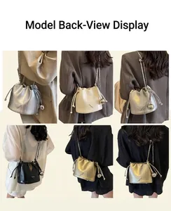 Detail shots of fashionable bucket bag with drawstring closure and metal chain strap