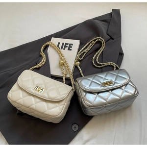 Detail of quilted leather mini bags in beige and silver with gold metal turn-locks