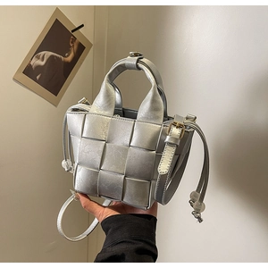 Détail du sac seau tissé argenté avec finition métallisée et détails de cordon serrage