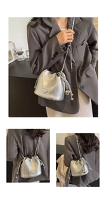 Detail of silver metallic bucket bag with vertical texture and chain strap
