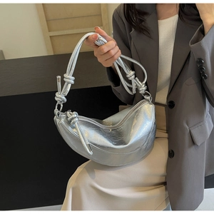 Silver crescent shoulder bag with metallic crinkle texture and knotted strap detail