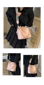 Detail der rosa Beuteltasche mit buntem breitem Ethno-Gurt und Metallic-Nieten