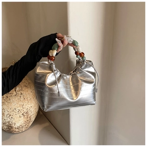 Detail of silver metallic cloud bag with unique chunky multicolored beaded handle