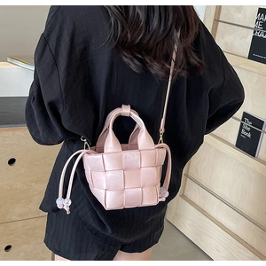 Détail du sac seau rose tressé avec cordon de serrage et décorations de perles claires