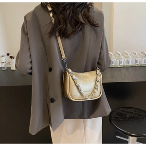 Λεπτομέρεια τσάντας χιαστί σε χρώμα σαμπάνιας με ασημένια αλυσίδα και λεπτό λουράκι δέρμα