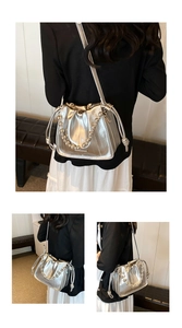 Detail of silver metallic bucket bag featuring vertical quilting and bead chain strap