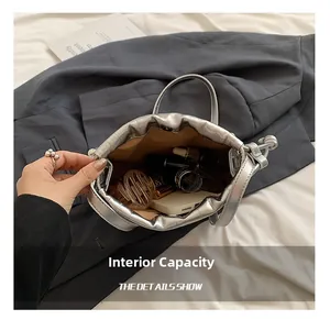 Top view of silver drawstring bucket bag showing interior space with phone and makeup