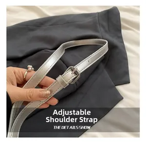Close-up of a metallic silver adjustable shoulder strap with a buckle detail