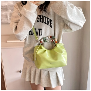 Lime green leather bucket bag featuring colorful acrylic bead handle and crossbody strap