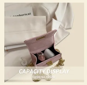 Interior view of pink mini crossbody bag showing storage for earphones and cosmetics