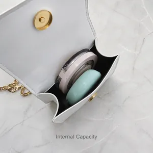 Internal capacity of mini white heart shoulder bag showing storage for makeup items