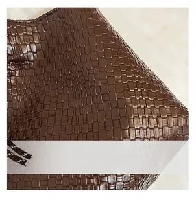 Détail du sac à bandoulière tressé en similicuir marron foncé avec texture treillis