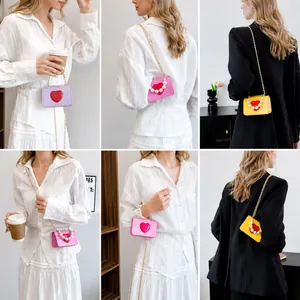 Mini heart-shaped crossbody bags with pearl handles and gold chains in various colors