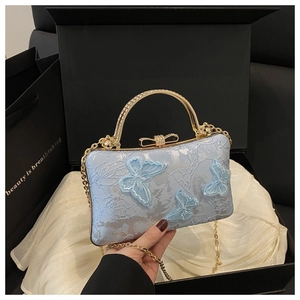 Detailed view of light blue embroidery evening bag with 3D butterfly appliques and diamonds