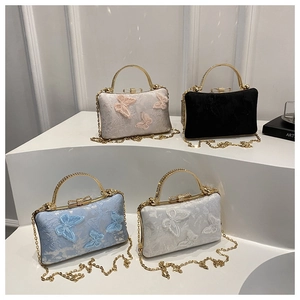 Detail of evening clutches featuring 3D butterfly embroidery and gold metal handles
