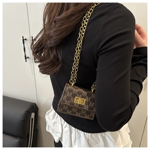 Detailed side view of mini monogram shoulder bag with gold chain and metal buckle