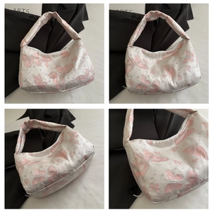 Détails de la broderie papillon blanche et du satin sur un sac à bandoulière demi-lune