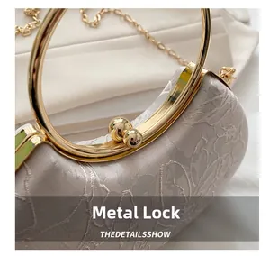 Detailed macro view of beige evening clutch with floral embroidery and golden metal clasp
