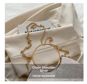 Close-up of floral embroidery texture and gold circular handle on a pink handbag