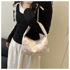 Détail de l'imprimé papillon rose et étoiles argentées sur un sac en tissu texturé