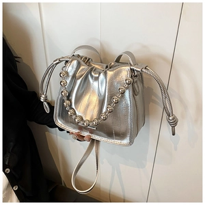 Detail of silver metallic drawstring bucket bag with chunky bead chain strap