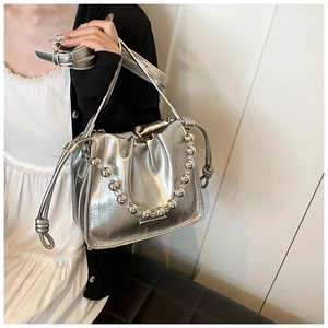 Detail view of silver liquid metal texture drawstring bag with metallic bead chain strap