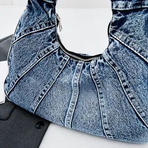 Detail van vintage blauwe denim hobo tas met patchwork en rits op een witte basis