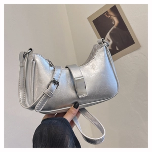Detail der silbernen Schultertasche aus Knitterleder mit Metallschnalle und Trägern