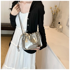 Detail of silver metallic drawstring bucket bag with pearl strap and triangle logo