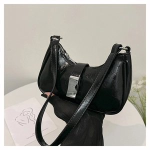 Detail der schwarzen Hobo-Tasche aus Lackleder mit markanter silberner Schnalle
