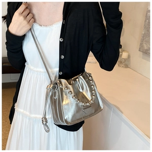 Detail of silver metallic bucket bag with gathered design and ball chain strap
