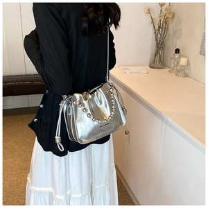 Detail of silver metallic drawstring bucket bag with beaded chain and triangle logo