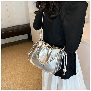 Detail of silver metallic drawstring bucket bag with triangular logo and metal beads