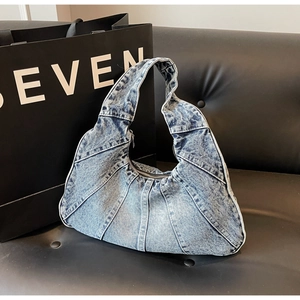 Detail van vintage denim schoudertas met patchwork plooien en gewassen textuur