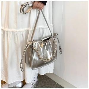 Detail of silver metallic drawstring bucket bag with decorative acrylic bead chain