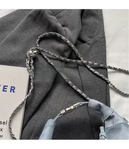 Detail of light blue denim dumpling bag with silver chain and adjustable metal bead