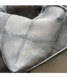 Close-up of light blue quilted fabric showing detailed knit texture and grid stitching