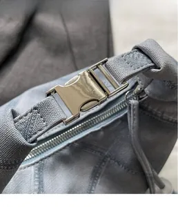 Close-up of premium light gold metal buckle and zipper on blue denim shoulder bag